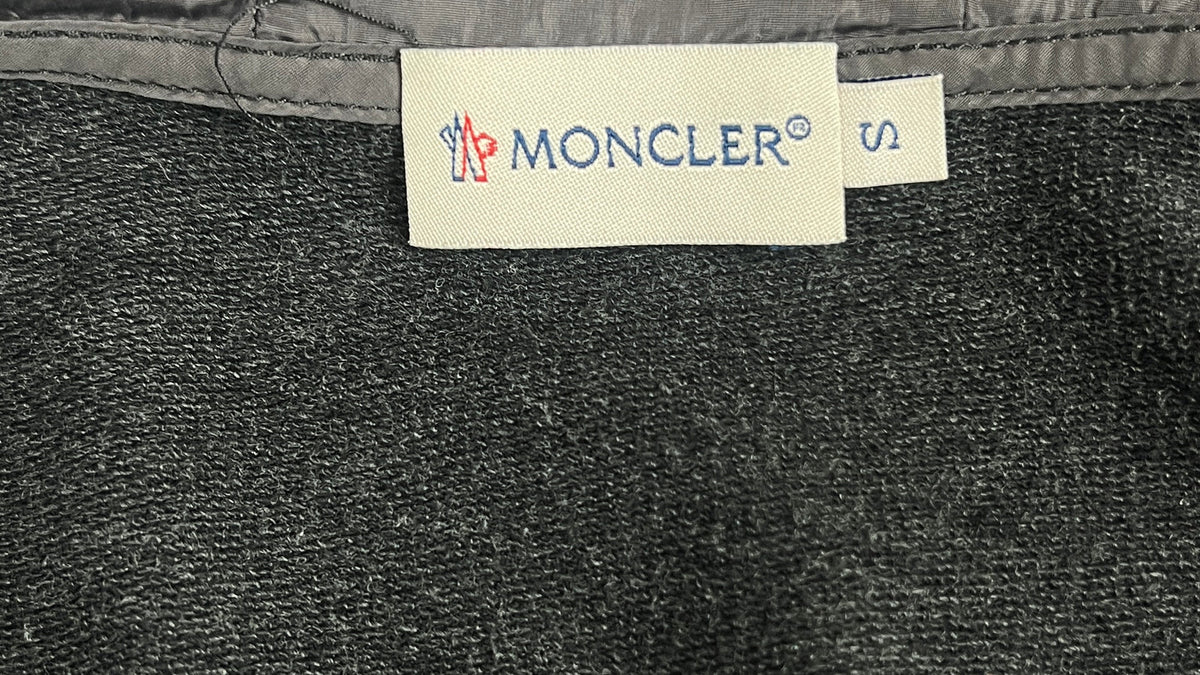 Étiquette intérieure d'un cardigan Moncler gris, marque née à Monestier-de-Clermont