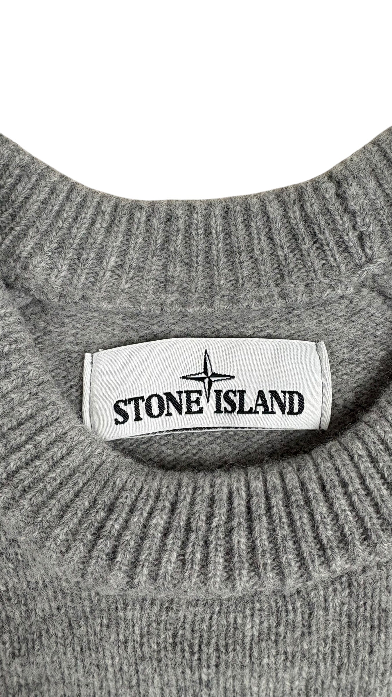 Étiquette de marque Stone Island cousue sur le col côtelé gris du pull