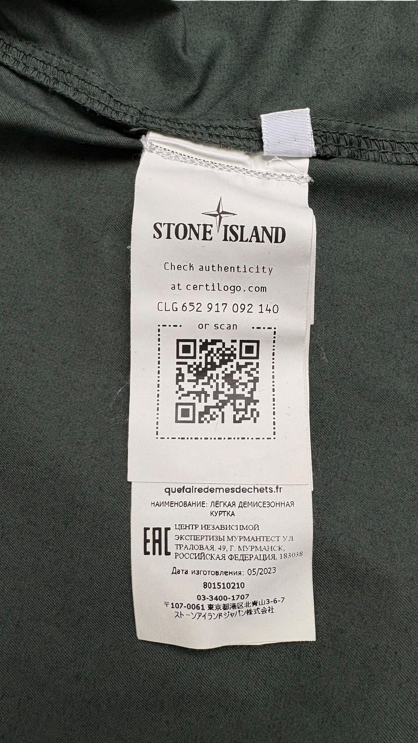 Étiquette intérieure de la surchemise Stone Island indiquant la composition, les instructions de lavage et un QR code Certilogo d'authenticité, vue détail