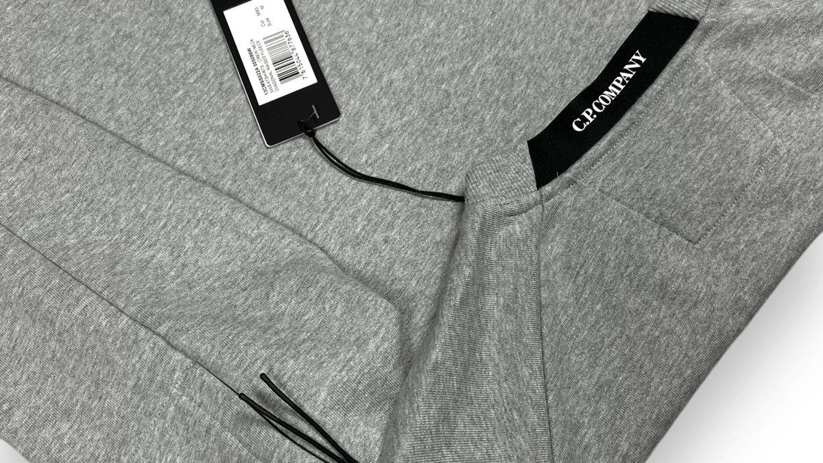 Logo C.P Company en gros plan sur un pull gris, en illustration des questions fréquentes sur la marque