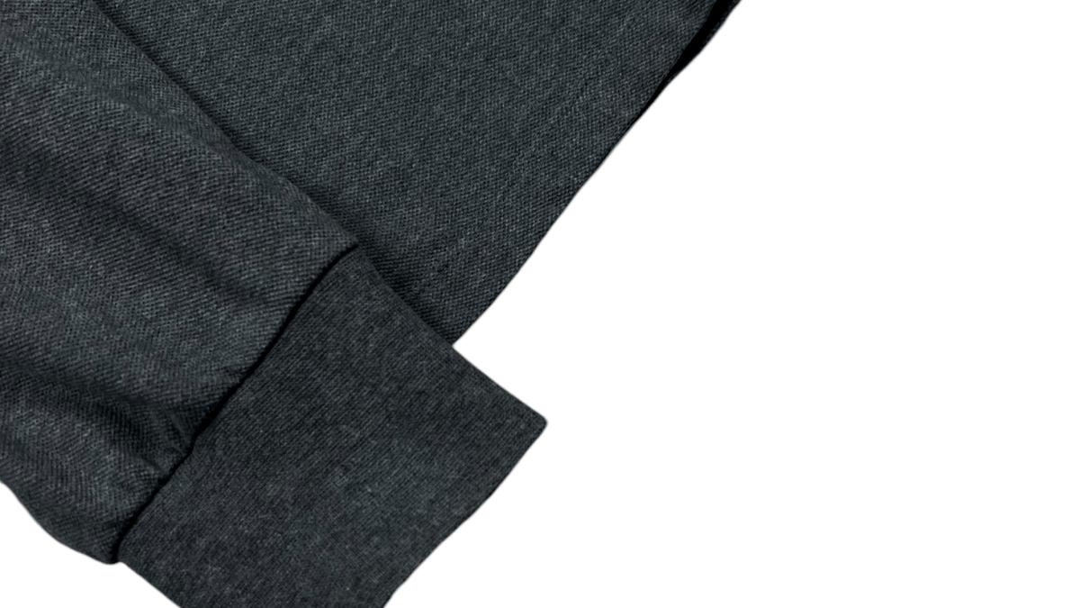 Badge Stone Island en gros plan sur un polo gris, en illustration des questions fréquentes sur la marque