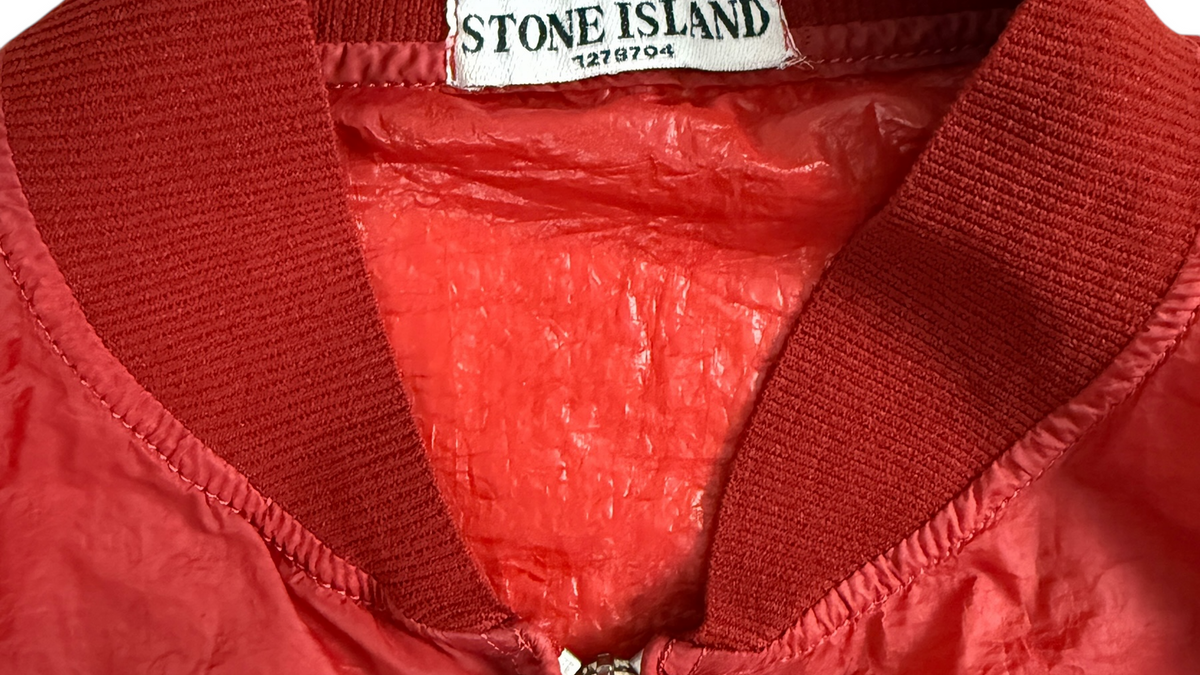 Badge boussole Stone Island en gros plan sur une veste vintage, signature de la marque depuis 1982