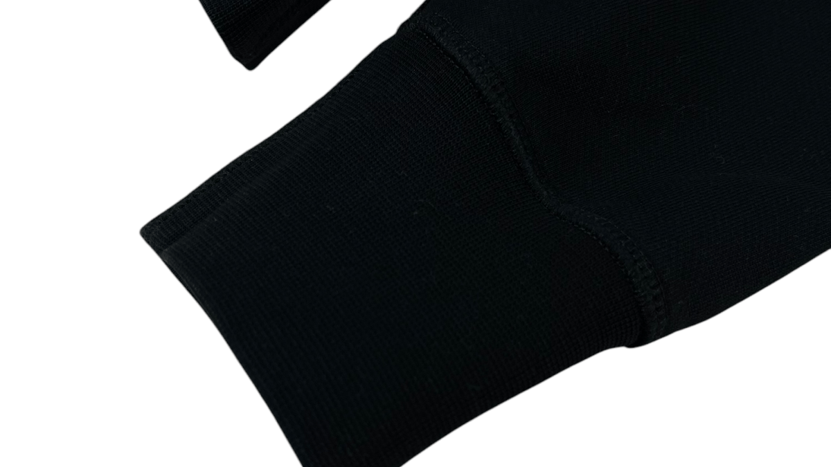 Logo Alexander McQueen en gros plan sur un pull noir authentifié chez NB08