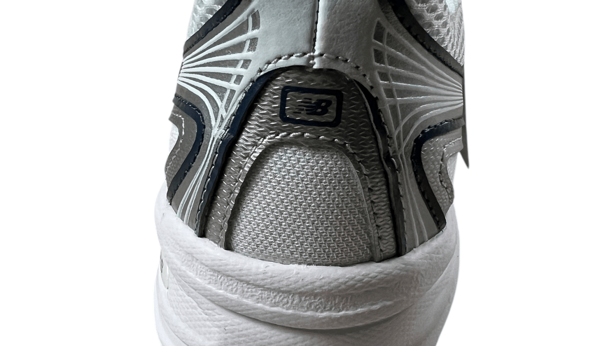 Logo New Balance en gros plan sur une sneaker blanche authentifiée chez NB08