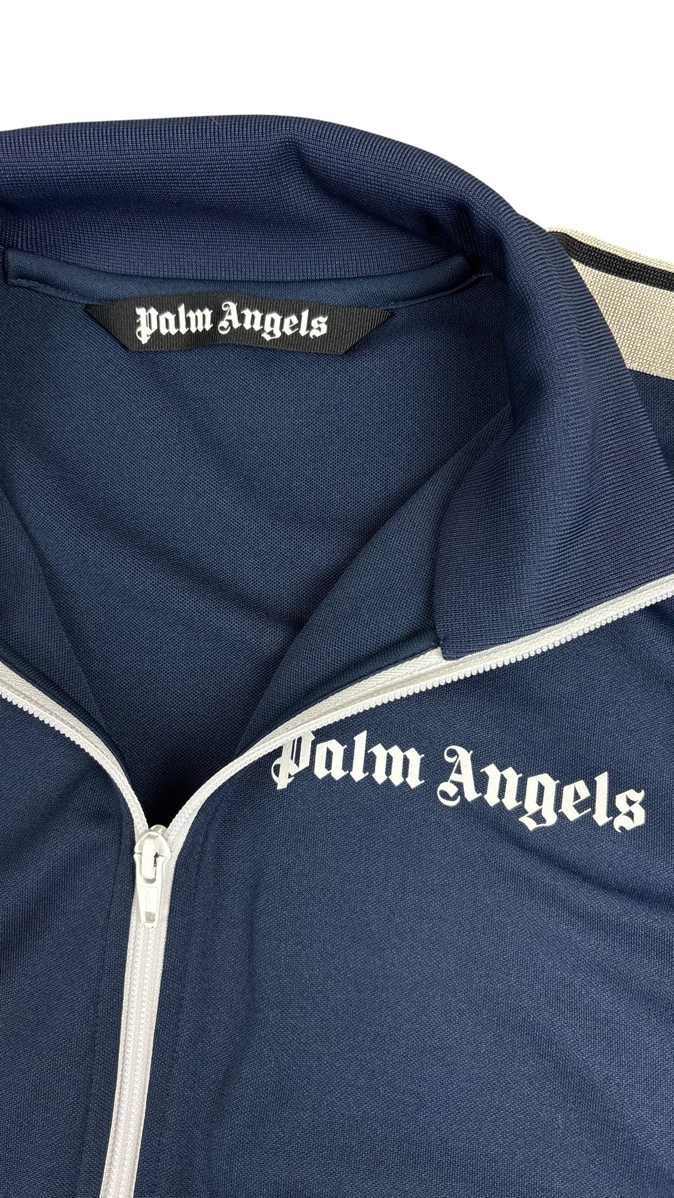 Détail du col de la veste Palm Angels bleu marine avec étiquette de marque et logo Palm Angels imprimé sous le zip