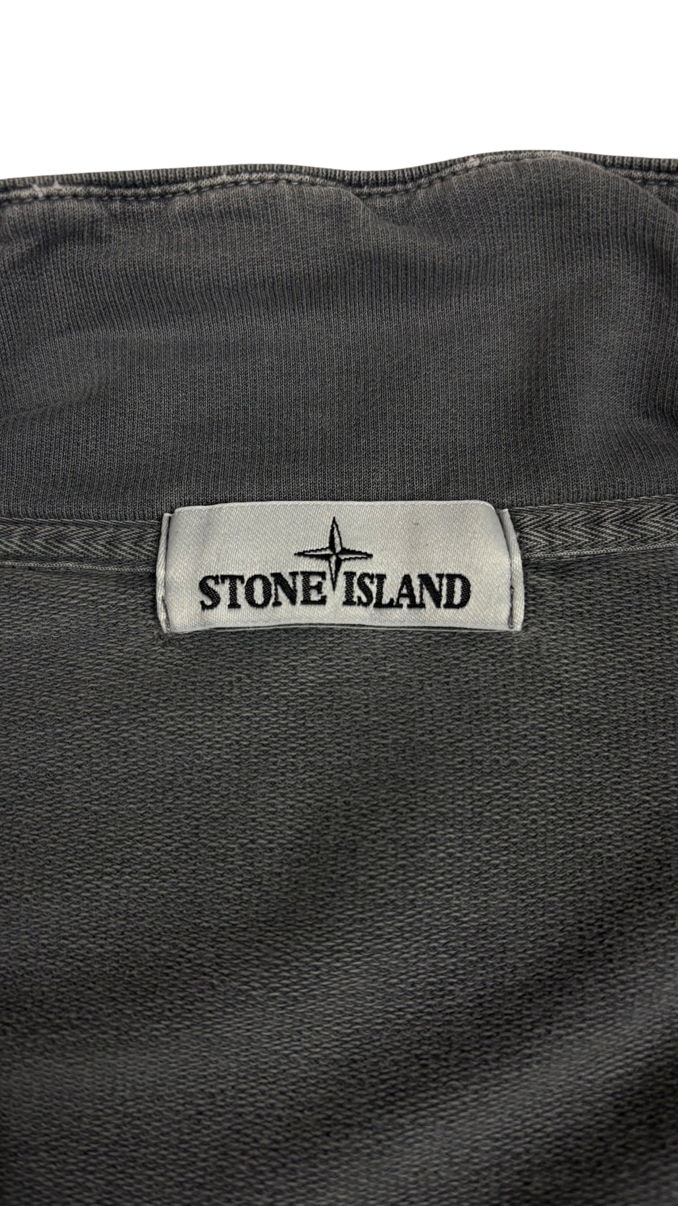 Etiquette de marque Stone Island cousue a l interieur de la veste grise