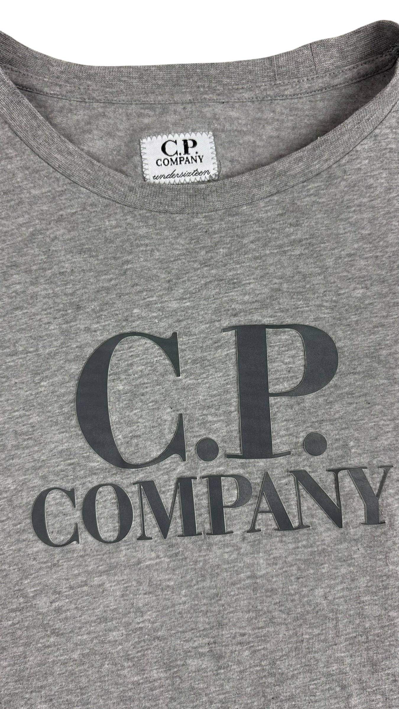 Détail du logo C.P Company imprimé sur l'avant et étiquette encolure C.P Company undersixteen du tee-shirt gris