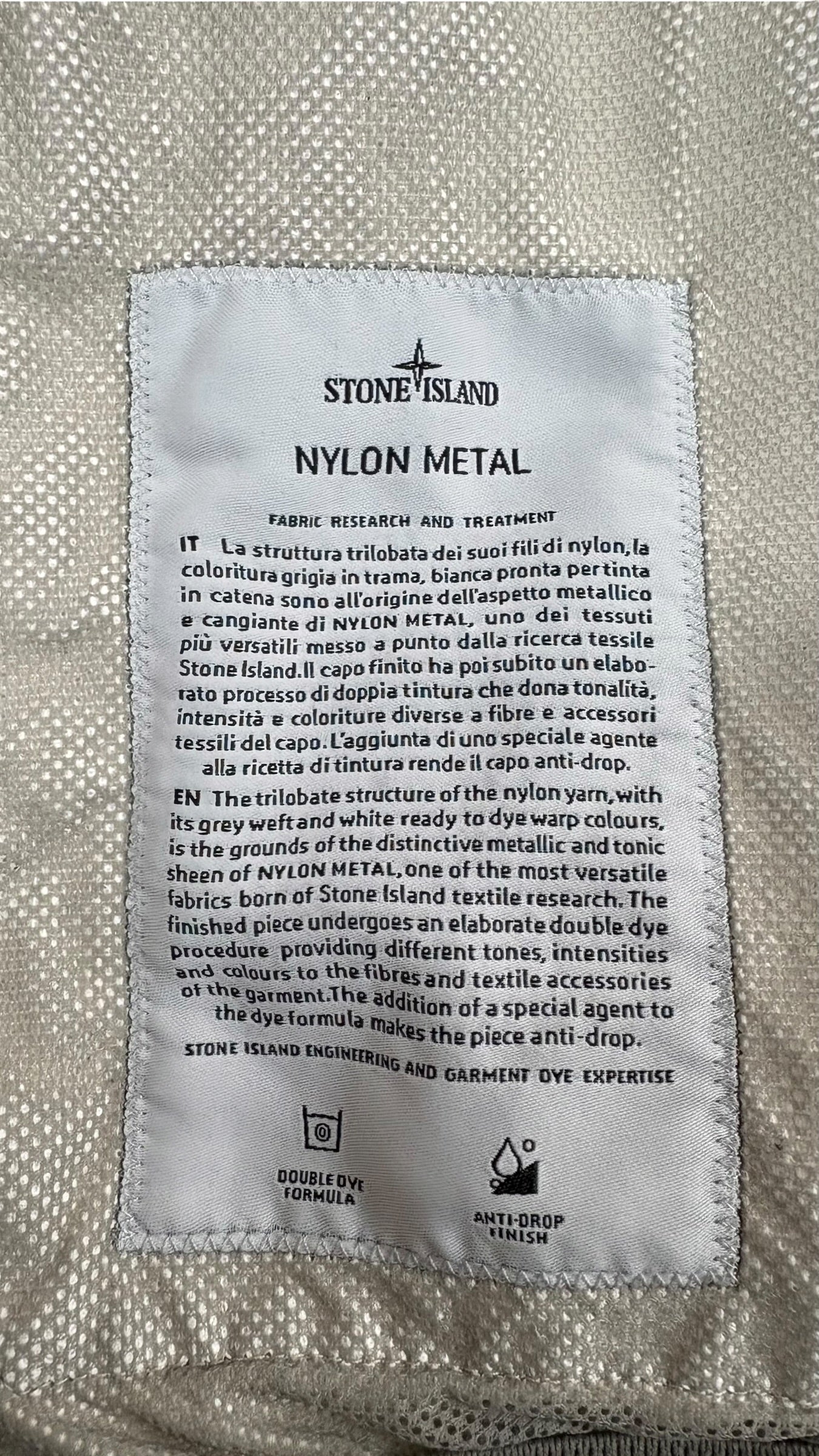 Étiquette descriptive Stone Island Nylon Metal détaillant la technologie du tissu et le procédé de teinture